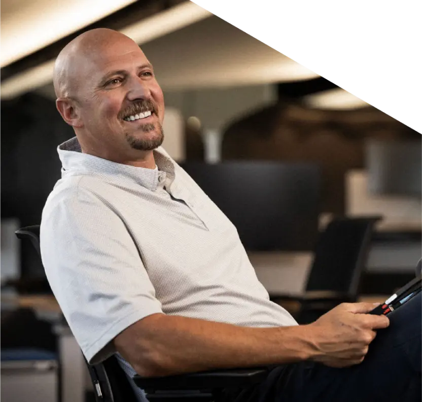 A locums physician smiles while relaxing and holding his phone