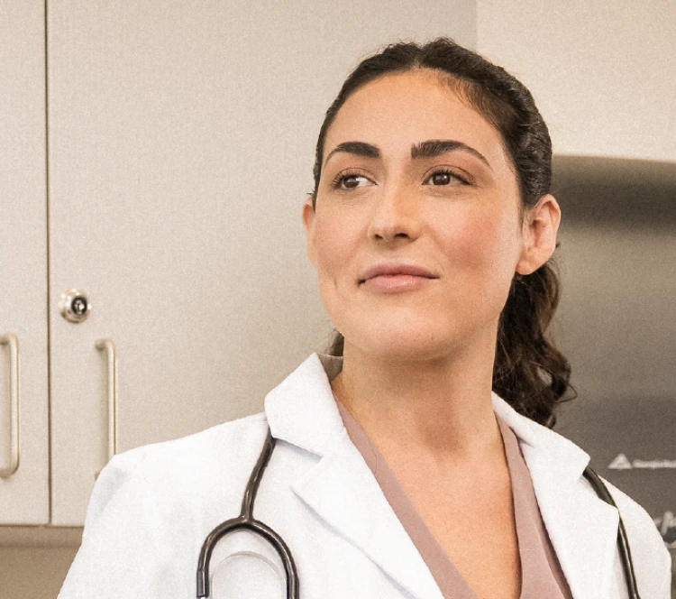 A locums physician in her office looks happy in her surroundings.